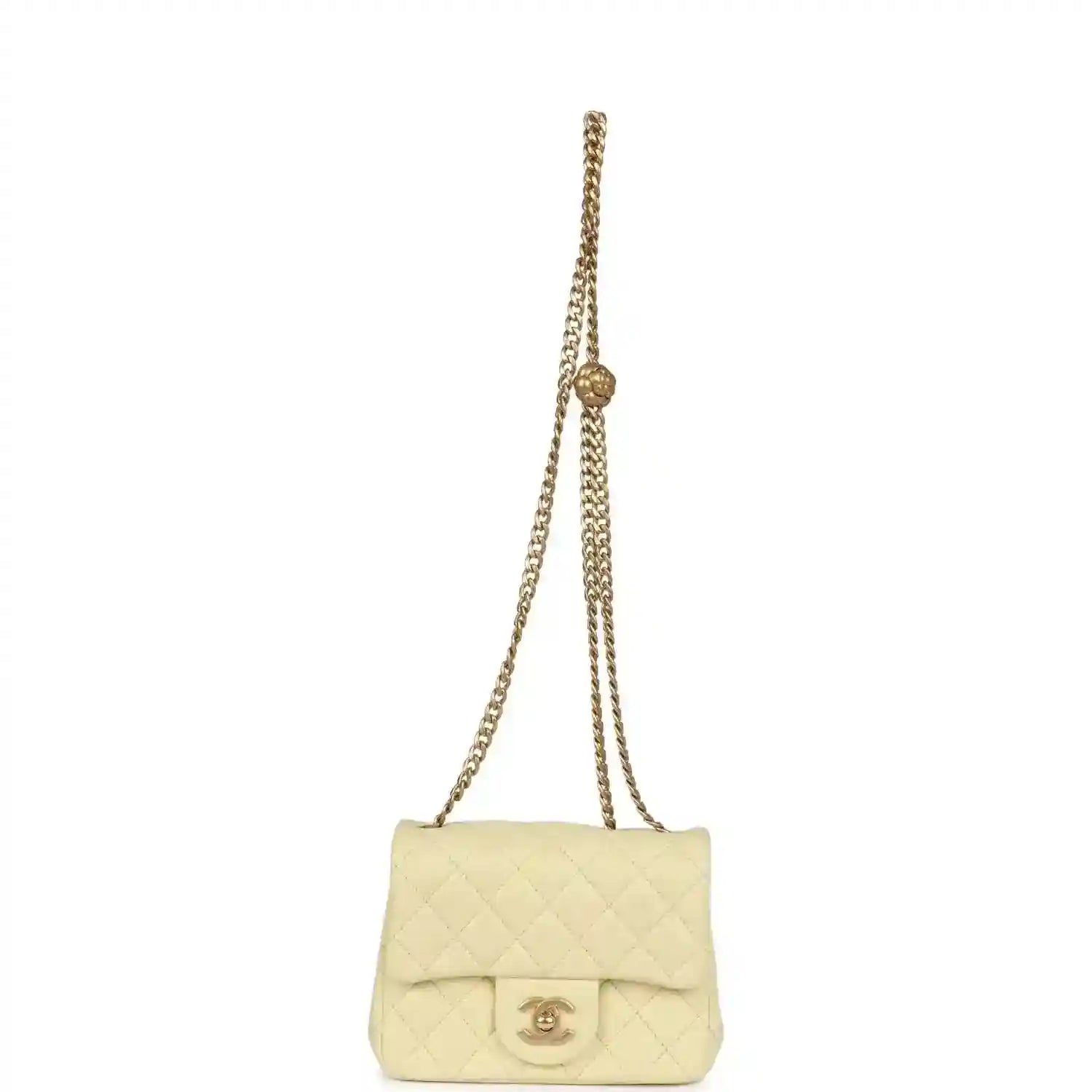 Mini quilted flap bag in pale yellow leather on gold chain shoulder strap