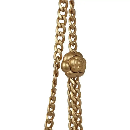 Gold chain shoulder strap detail with sculpted camellia-style charm