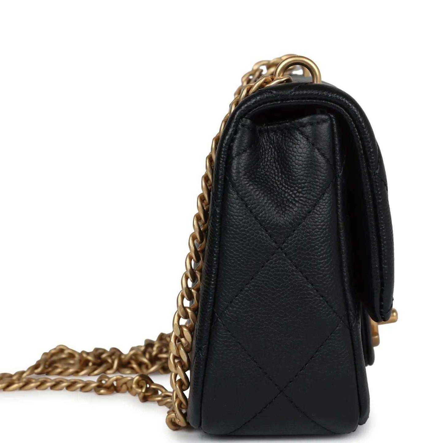 Black quilted mini flap bag with gold-tone chain strap, side profile view.