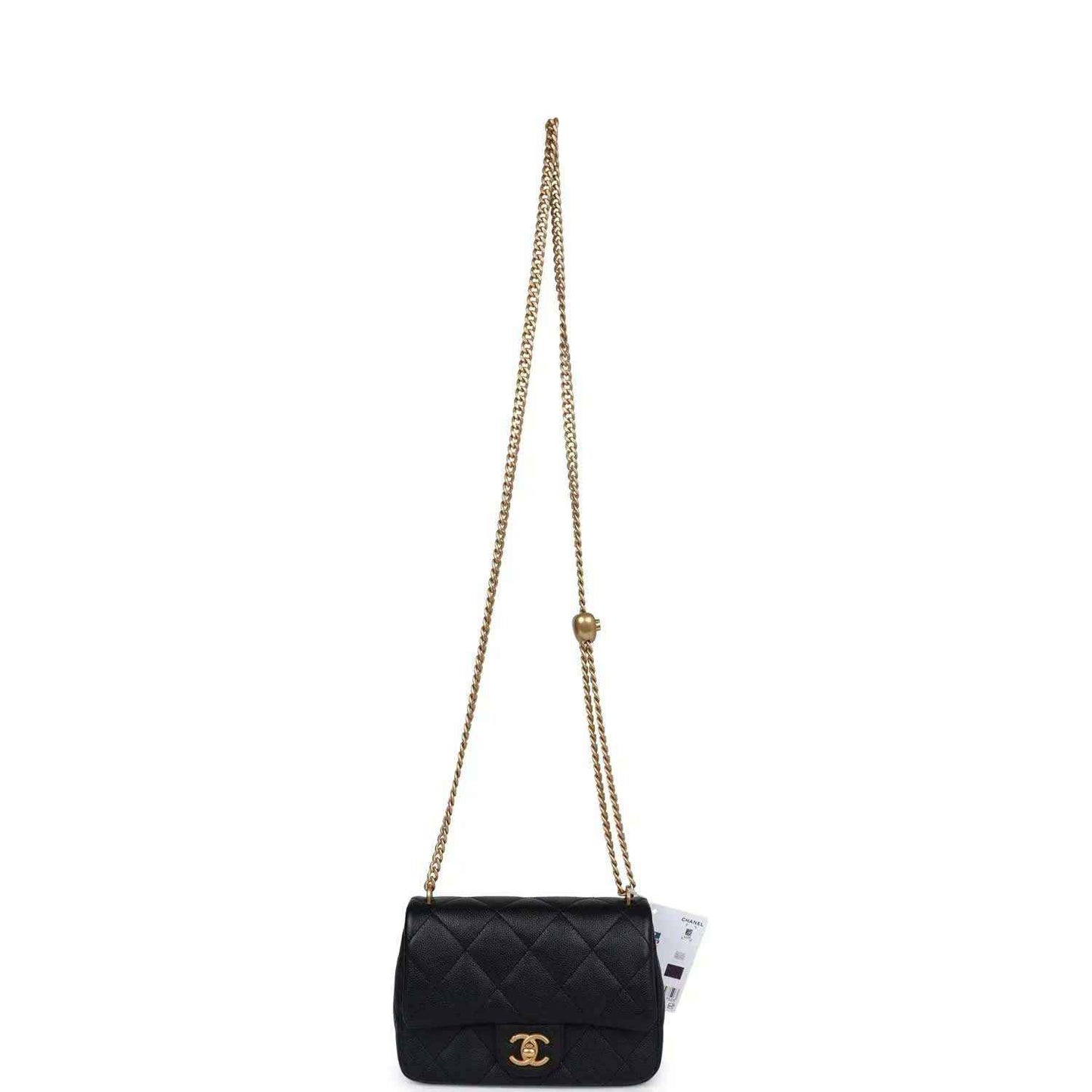 Black quilted mini flap bag on long gold chain strap.