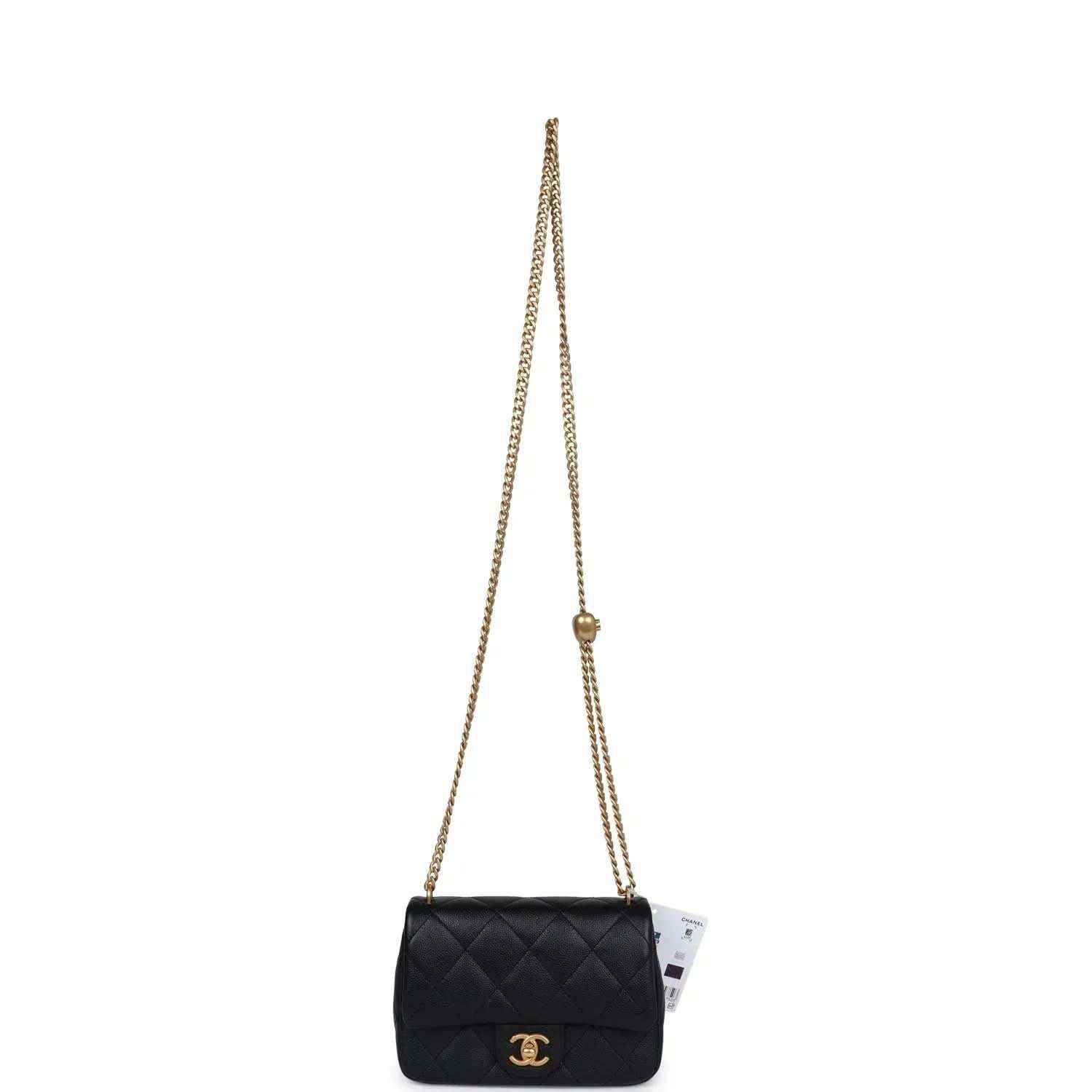 Black quilted mini flap bag on long gold chain strap.