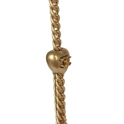 Gold-tone CC charm on linked chain strap for mini flap bag.