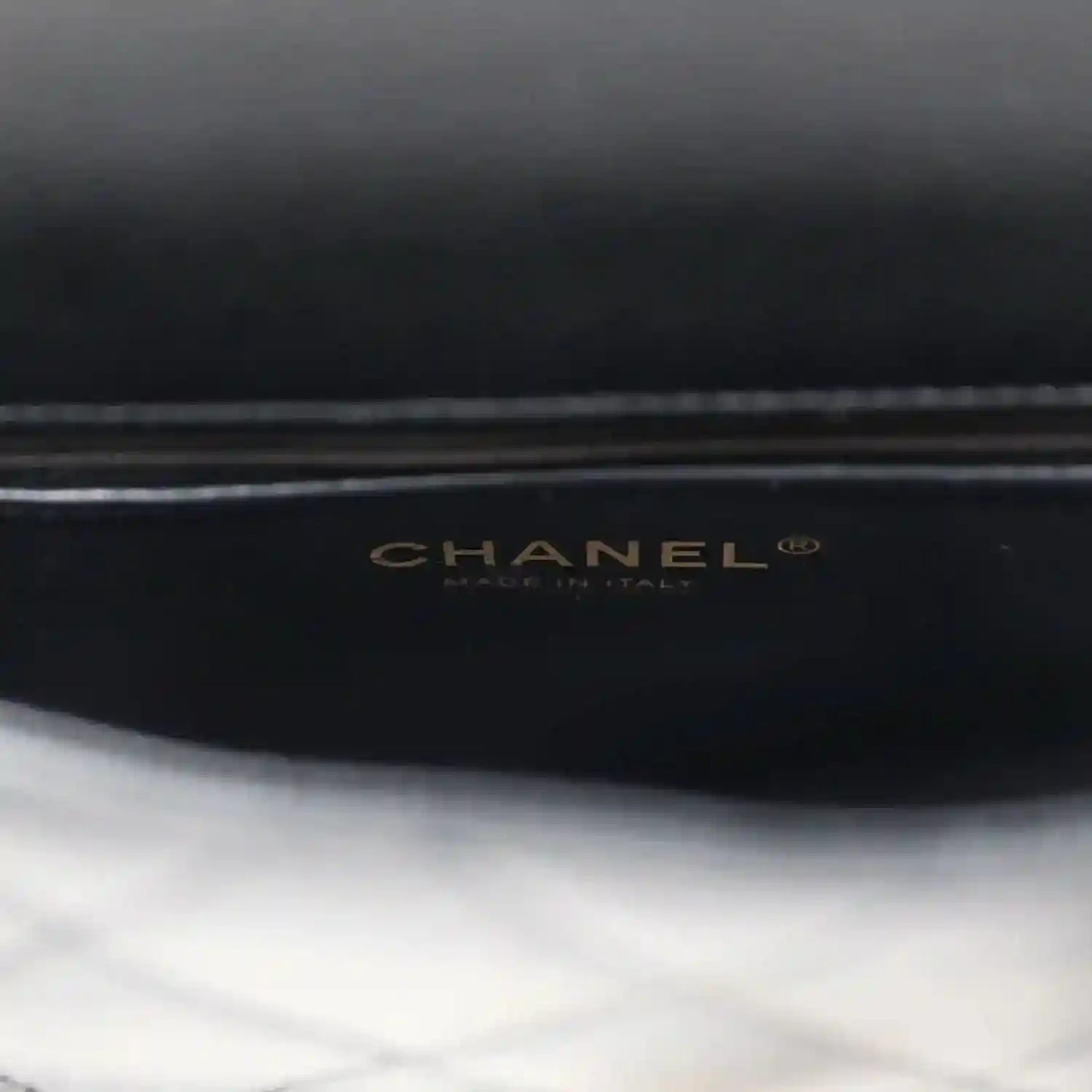 CHANEL logo on black lining of mini flap bag.