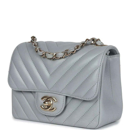 Light grey mini shoulder bag with flap, chevron stitching, and gold-tone CC logo clasp