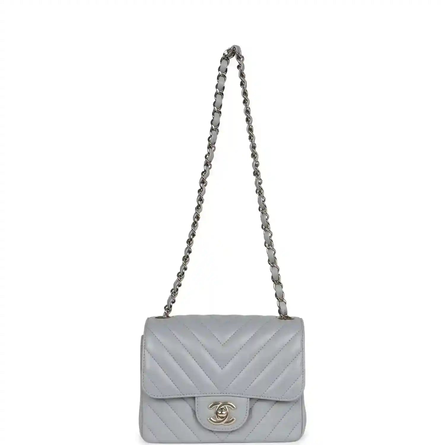 Light grey mini shoulder bag with flap, chevron quilting, and chain strap