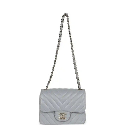 Light grey mini shoulder bag with flap, chevron quilting, and chain strap