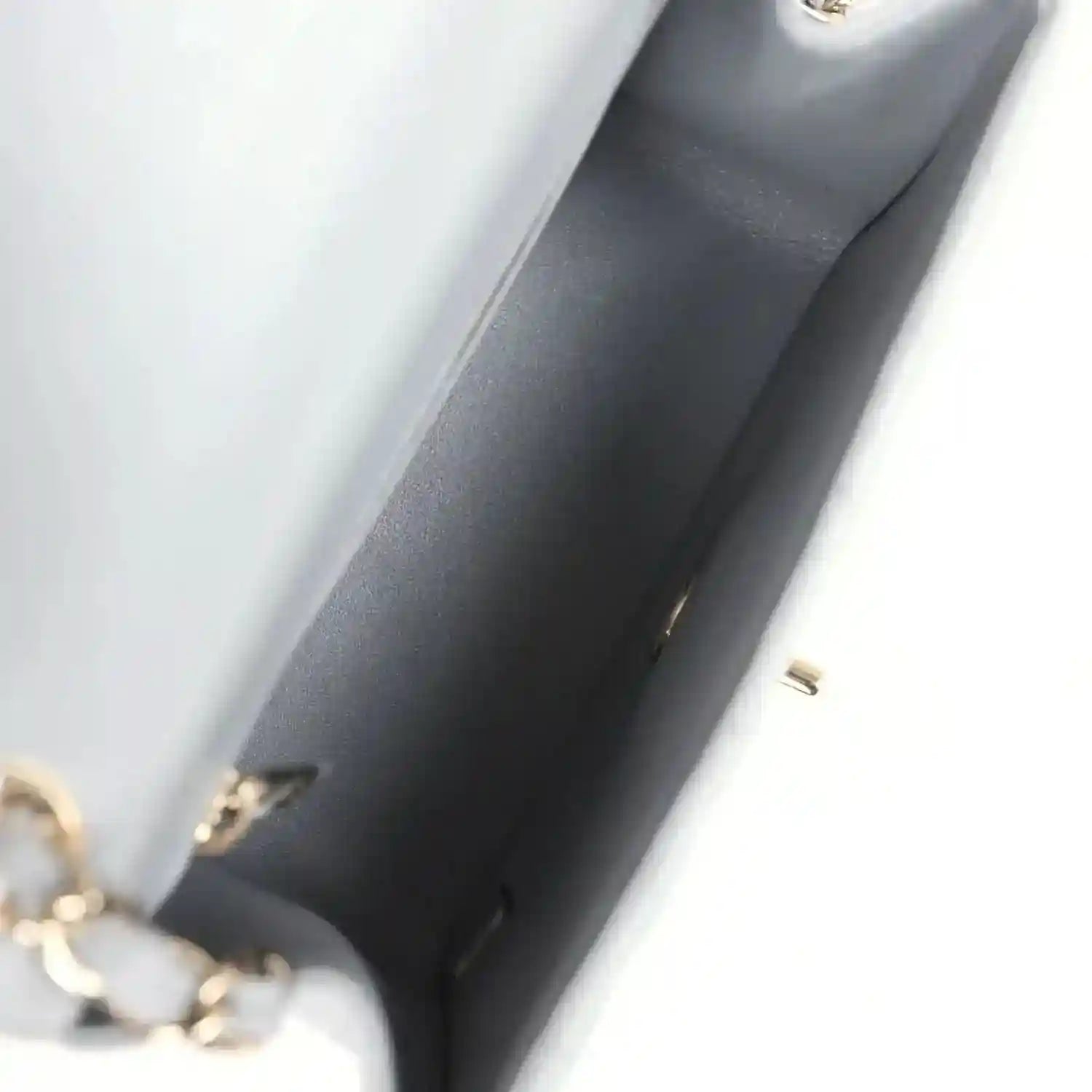 Light grey bag lining corner with gold-tone hardware and interior seam