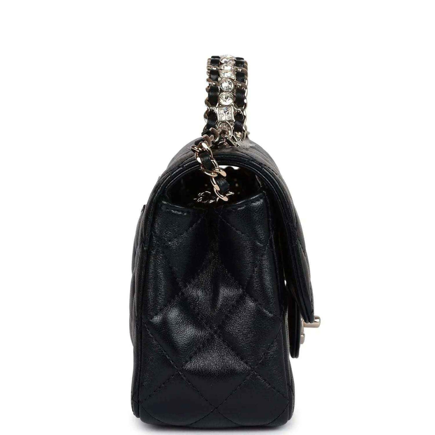 Side view of mini black quilted leather flap bag with chain strap and small hardware tab