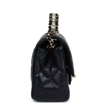 Side view of mini black quilted leather flap bag with chain strap and small hardware tab