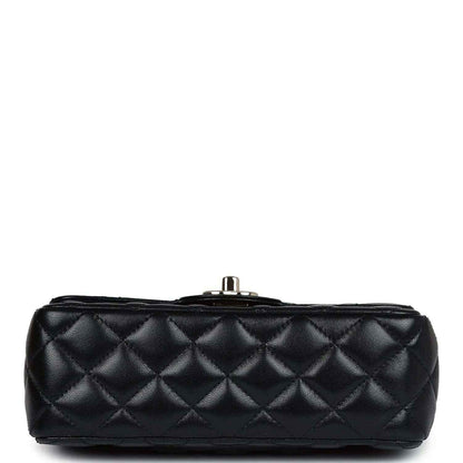 Top view of mini black quilted leather flap bag with metal post closure