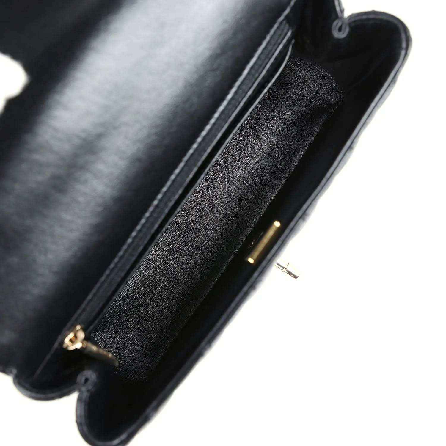 Close-up of black leather bag edge with gold-tone zipper pull and seam stitching