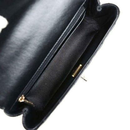 Close-up of black leather bag edge with gold-tone zipper pull and seam stitching