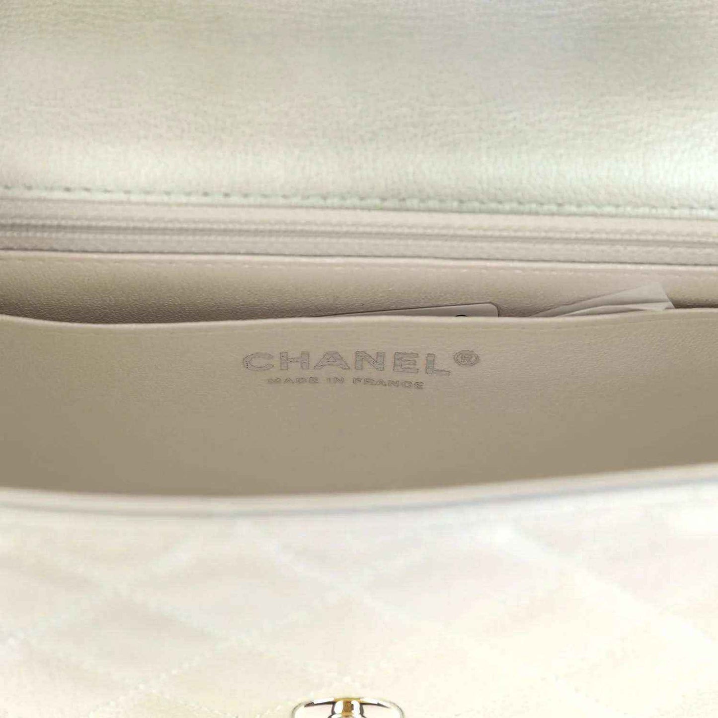 Mini flap bag interior close-up with Chanel-branded stamp on leather lining