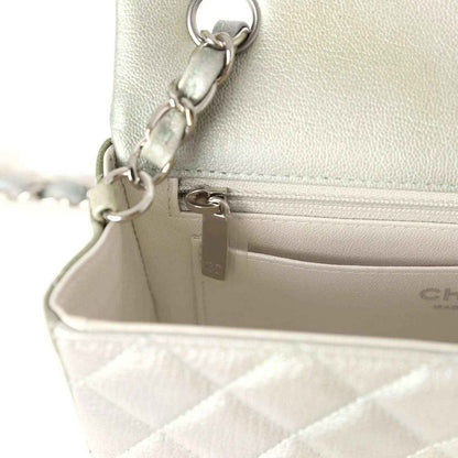 Mini flap bag close-up of zipper track and chain hardware on leather lining