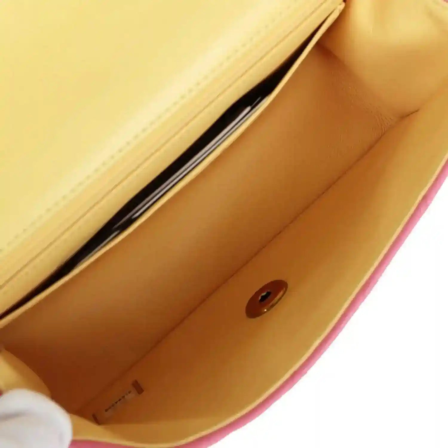 Pink mini flap bag interior with beige lining and snap button on the front wall