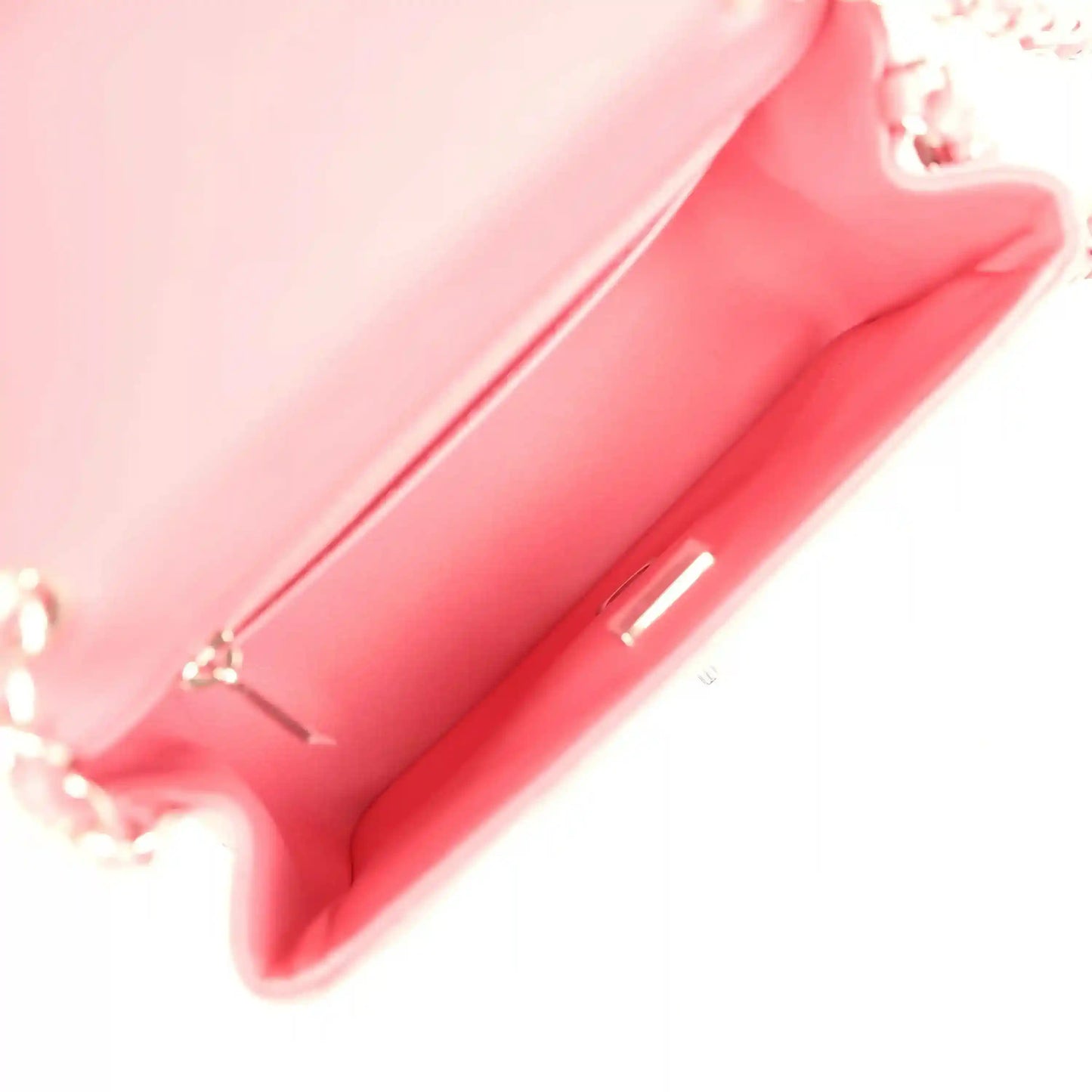 Pink leather-lined interior of mini flap bag with zip-top opening and seams