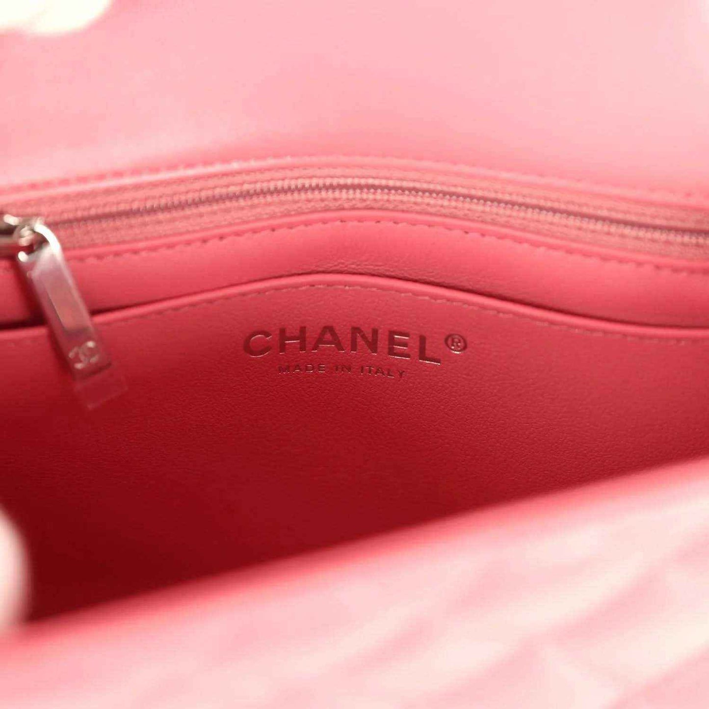 Pink leather-lined interior of Chanel mini flap bag with CHANEL logo stamp