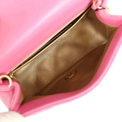 Pink mini flap bag interior with tan leather lining and gold-tone frame edge.