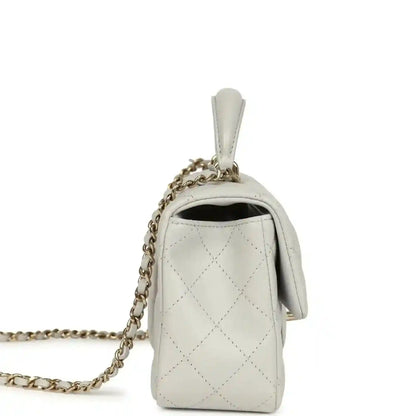 Chanel mini flap bag showing side opening, quilted light leather with chain strap