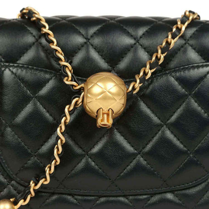 Black quilted mini flap bag close-up of gold CC logo and chain