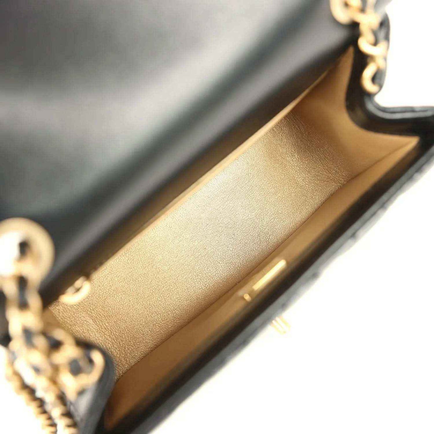 Mini flap bag interior with tan lining and gold hardware edge