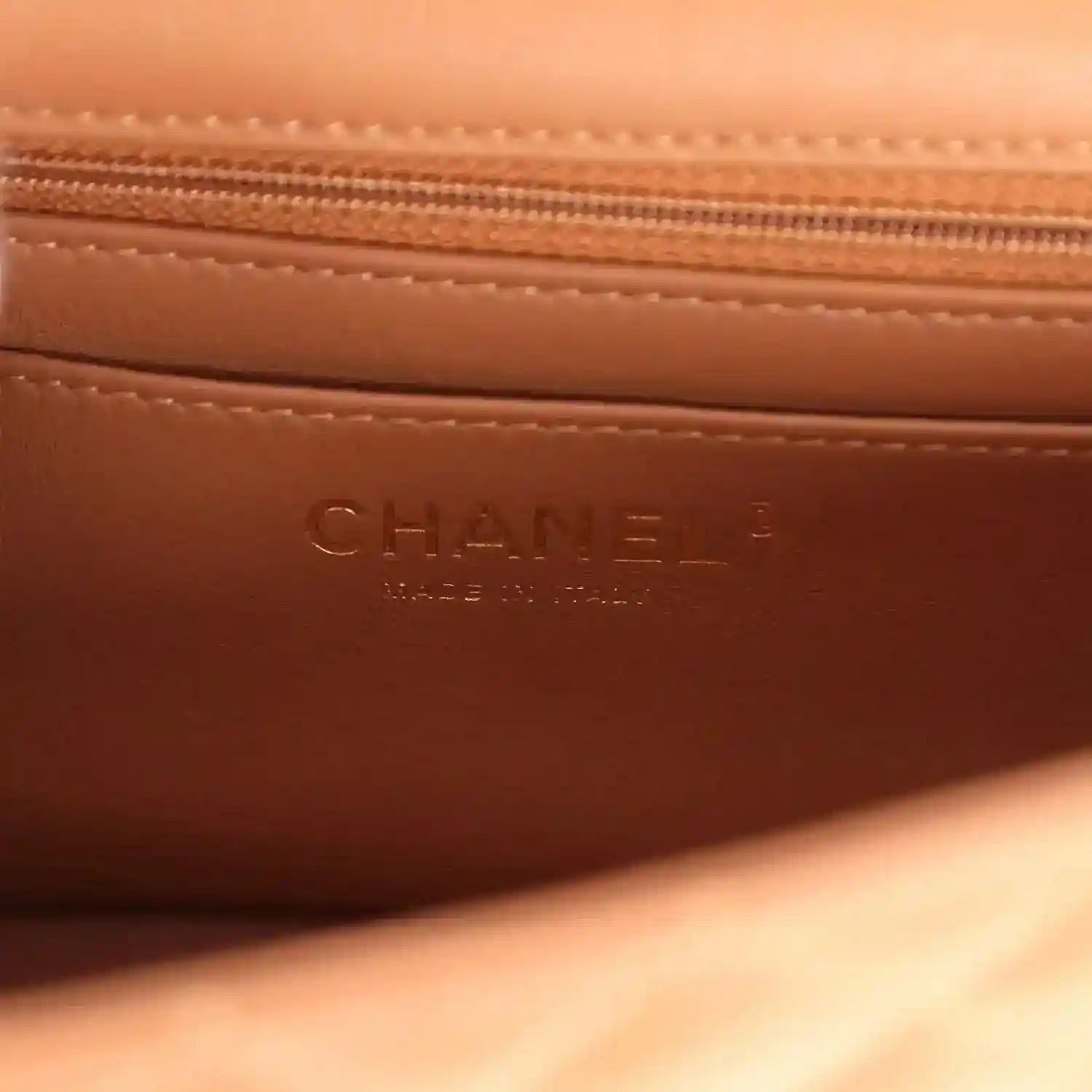 Caramel leather interior pocket with stamped CHANEL and stitched zipper seam