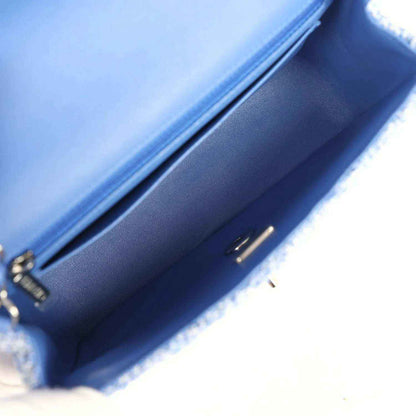 Blue leather-lined mini flap bag interior with zip pull and stitched edge