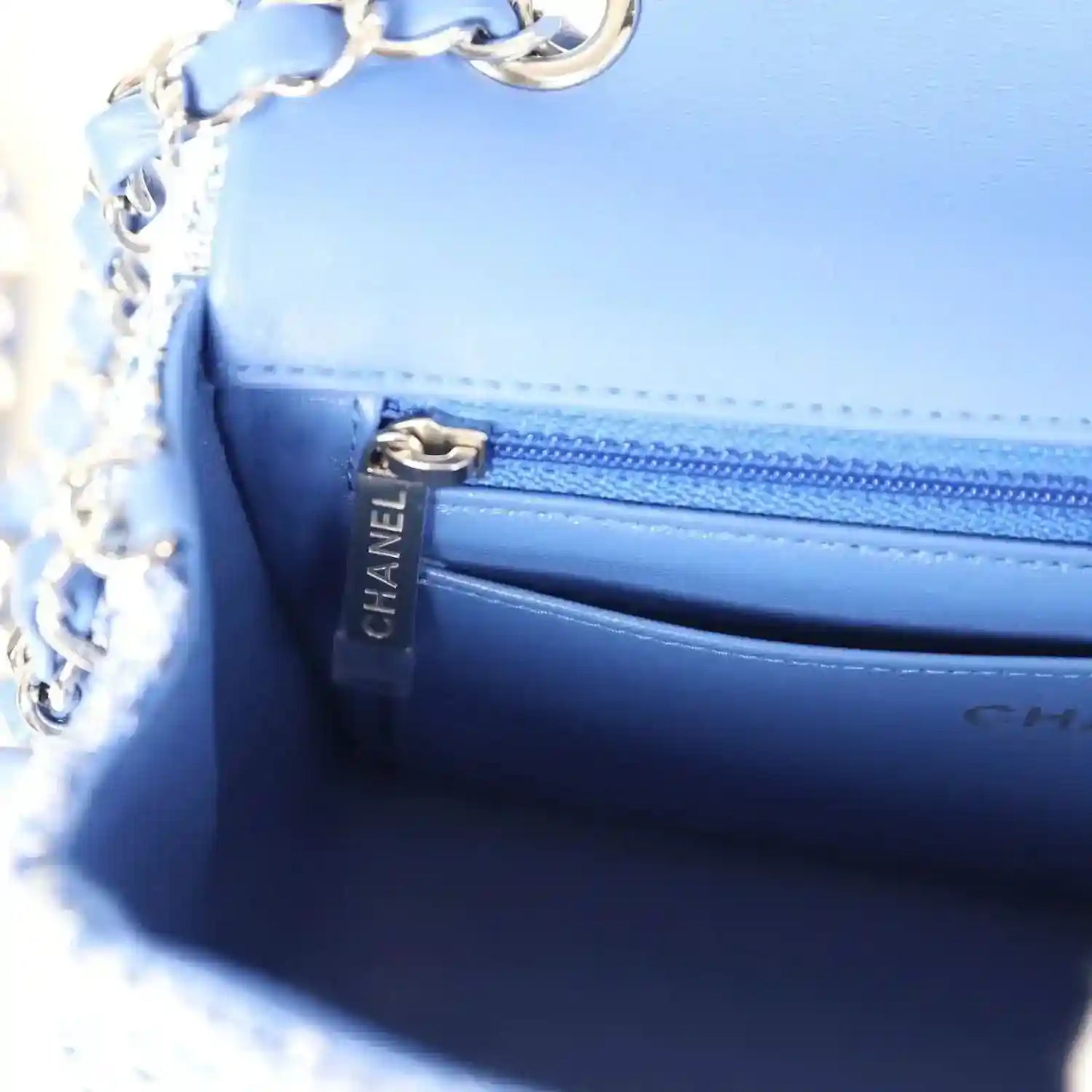 Blue leather-lined mini flap bag interior with CHANEL branding and zipper