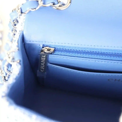 Blue leather-lined mini flap bag interior with CHANEL branding and zipper