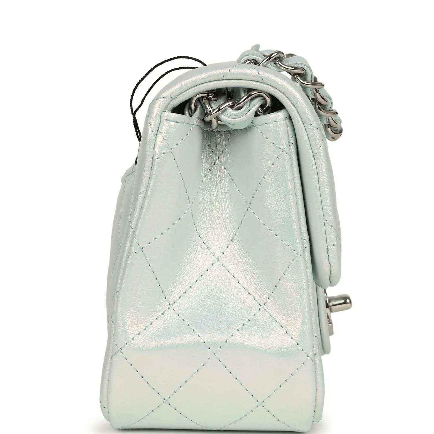 Mini square flap bag side view in iridescent light blue quilted leather with short handle strap