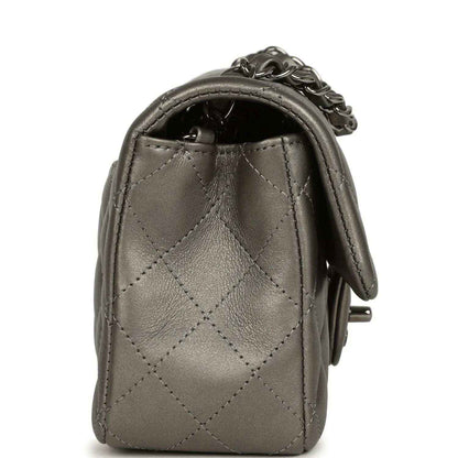 Silver quilted flap bag side view with chain strap and stitched diamond pattern