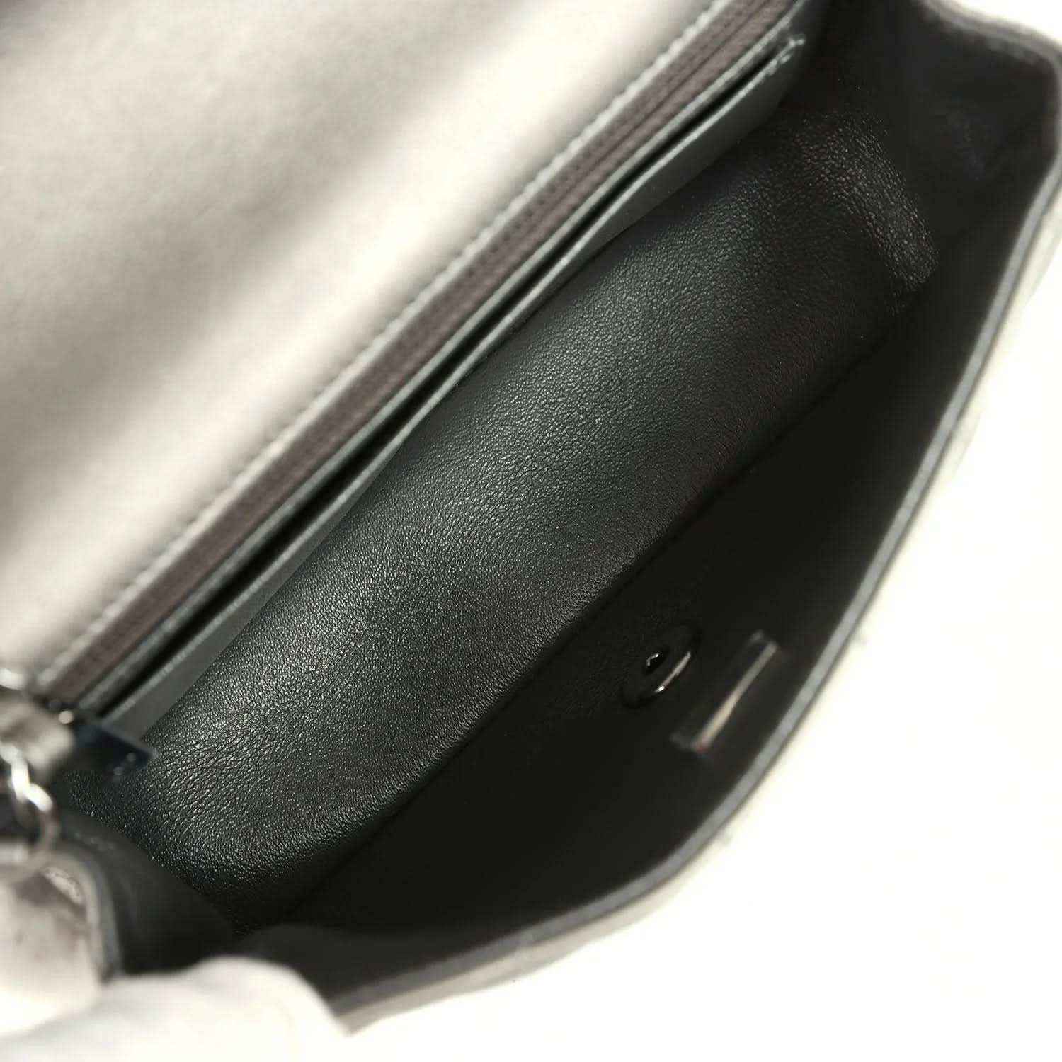 Silver bag interior with dark lining and top zipper track visible