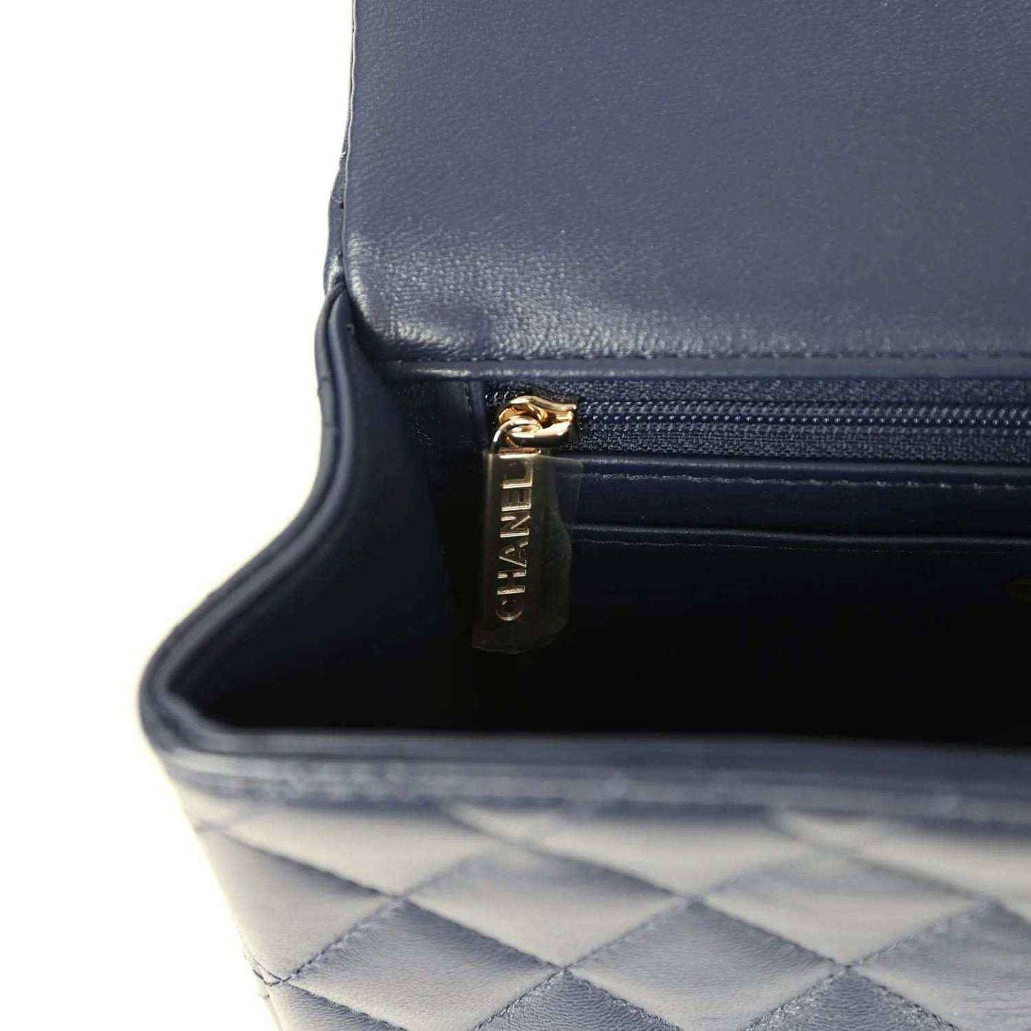 Navy interior pocket with quilted lining and gold-tone zipper pull