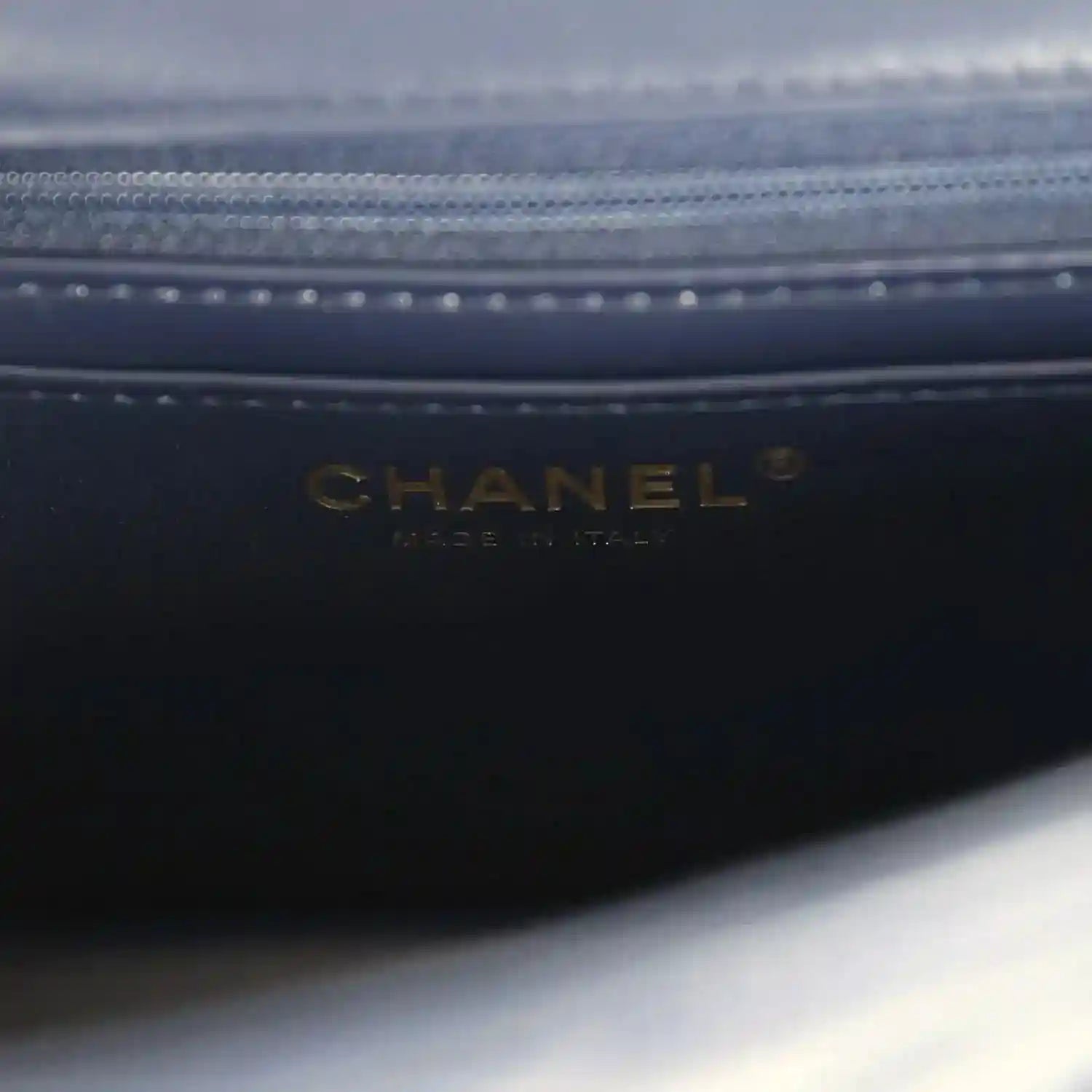 Dark navy leather bag lining with CHANEL logo debossed near zipper
