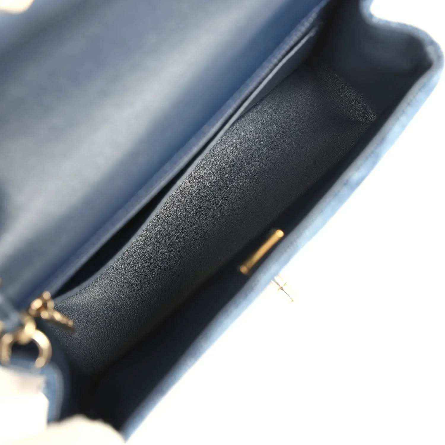Chanel mini flap bag interior view, blue leather lining and gold clasp hardware