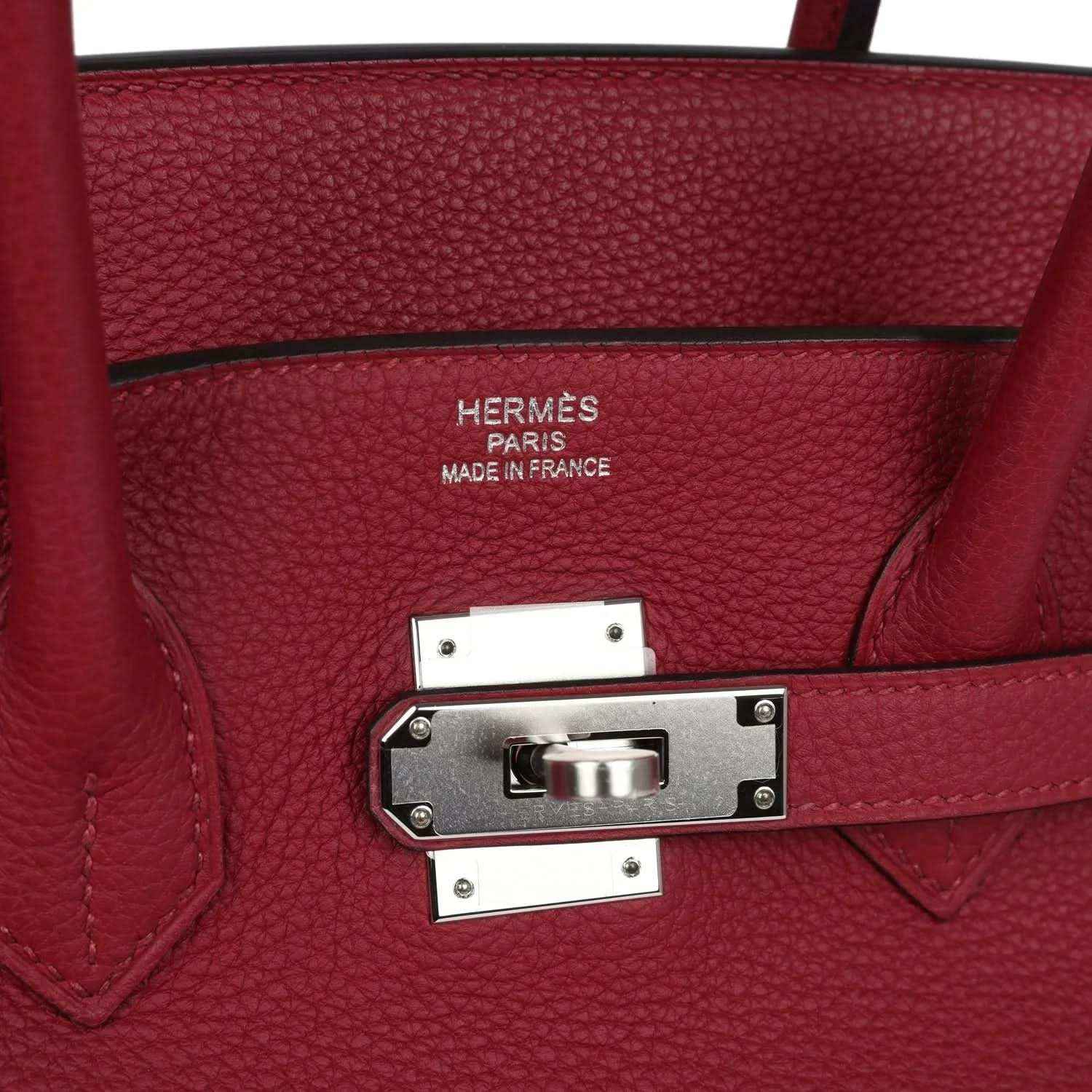 Red leather handbag with front turn-lock clasp and engraved “Hermès Paris Made in France”