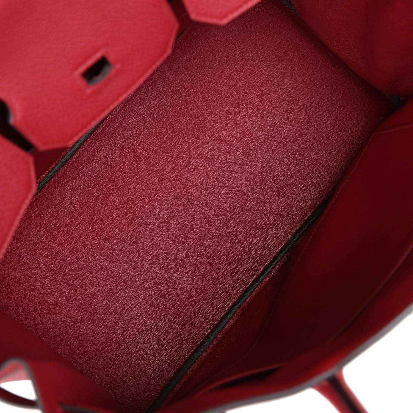 Red leather handbag interior view showing smooth lining and inner edge trim