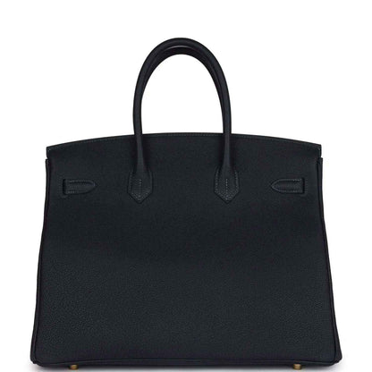 Leather Birkin handbag front with structured flap, handles, and minimal gold accents, dark