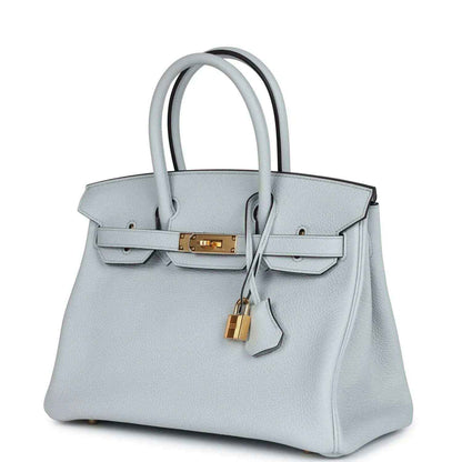 Pale blue leather handbag with gold turn-lock, top handles, and front flap lock charm