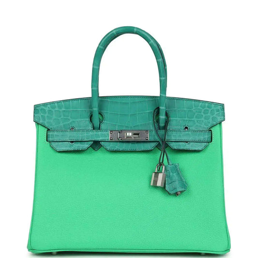 Green leather handbag with crocodile-texture panels, top handle, and front flap clasp