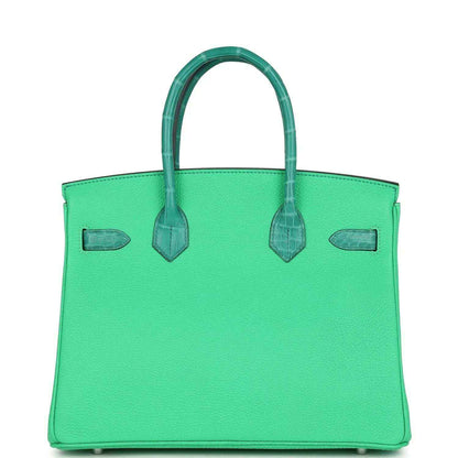 Green leather handbag front with top handles, crocodile-texture accents, and side flap pockets