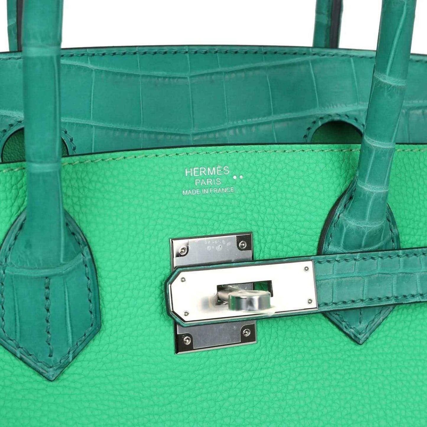 Green leather handbag interior front panel with logo stamp and metal turn-lock hardware