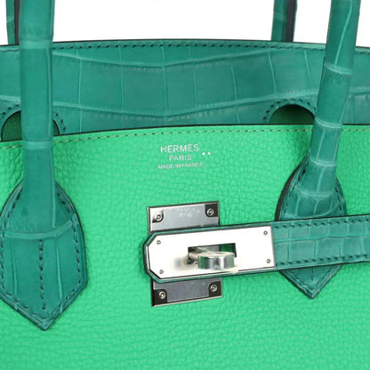 Green leather handbag interior front panel with logo stamp and metal turn-lock hardware