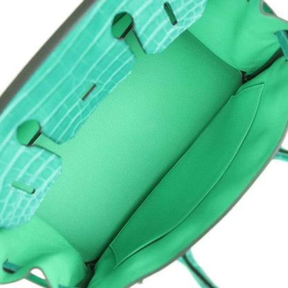 Green leather handbag interior lining with stitched seams and inner pockets