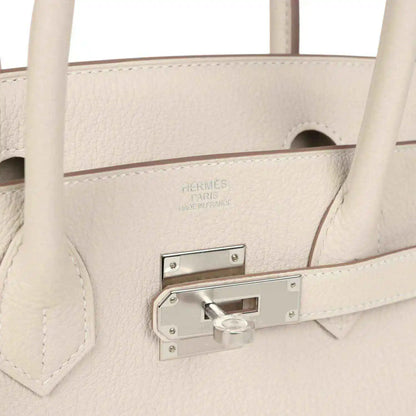 Birkin 30 handbag close-up of light cream leather with stamped logo and padlock bar
