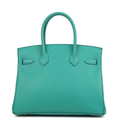 Green leather handbag with top handles and structured silhouette