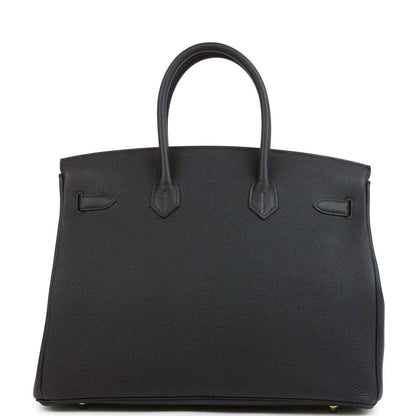 Black leather handbag with top handles and front flap detailing