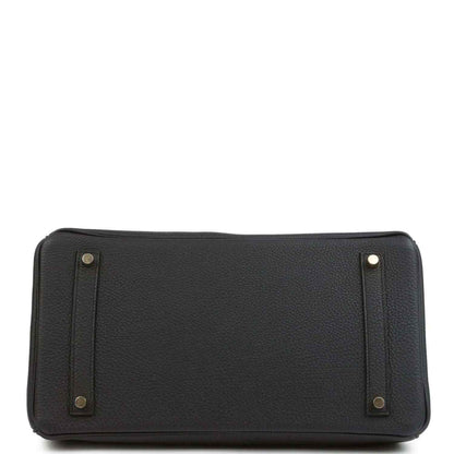 Black leather handbag with reinforced base corners and side handle attachments