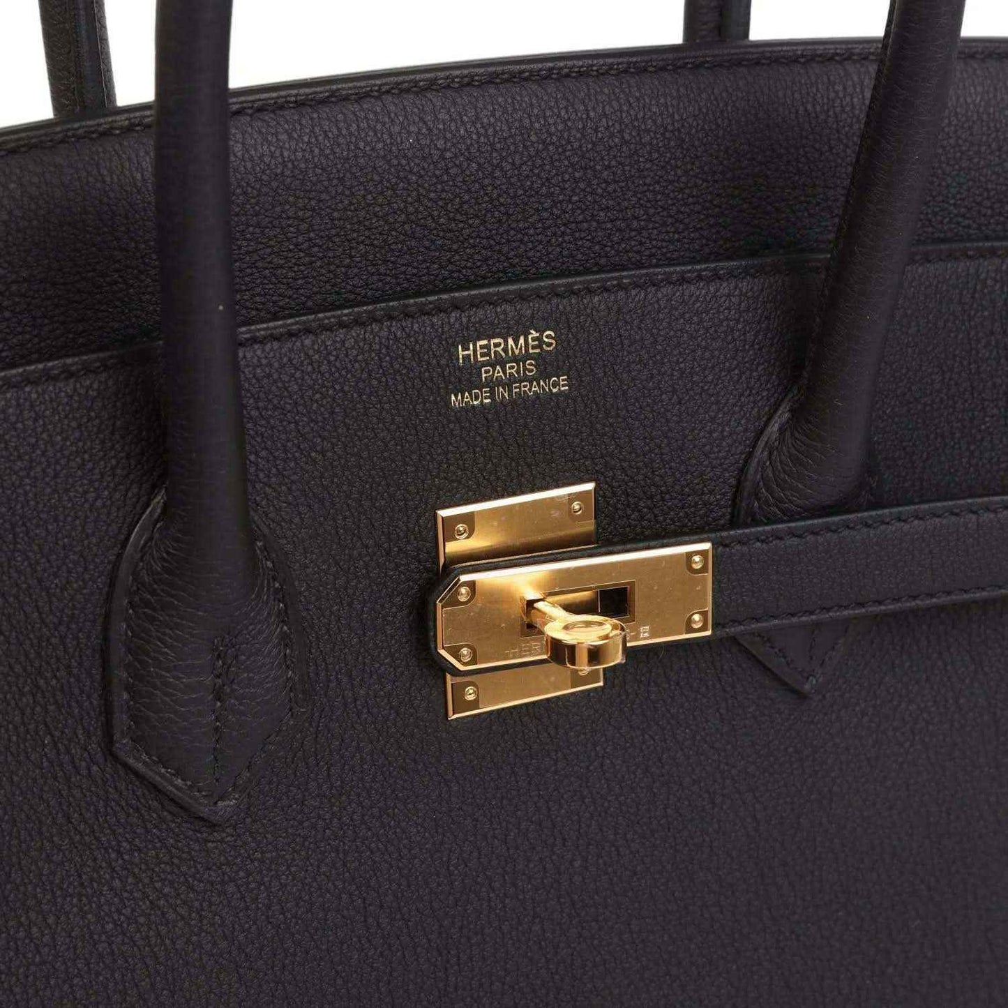 Black leather handbag interior pocket with HERMÈS PARIS stamp and gold clasp