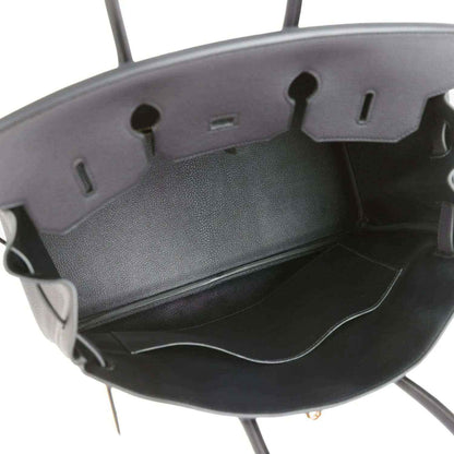 Black leather handbag interior with side pockets and open top frame